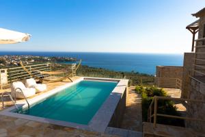 a swimming pool with a view of the ocean at Tseralia Houses in Stoupa