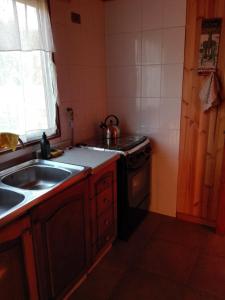 a kitchen with a sink and a stove at Cabaña Amor in Isla de Maipo
