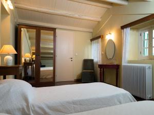 a bedroom with a bed and a desk and a mirror at Villa De Loulia in Peroulades