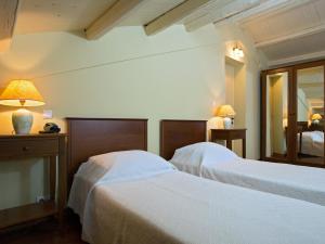 a bedroom with two beds and a mirror at Villa De Loulia in Peroulades