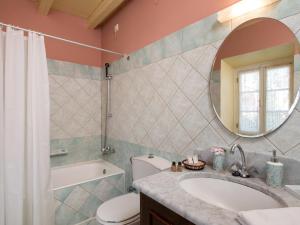 a bathroom with a sink and a toilet and a mirror at Villa De Loulia in Peroulades