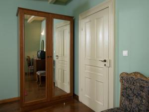 a room with a door and a chair and a mirror at Villa De Loulia in Peroulades