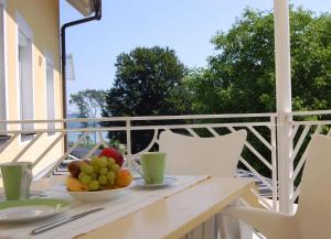 einen Tisch mit einer Obstschale auf dem Balkon in der Unterkunft Buchenheim Apartments in Reifnitz