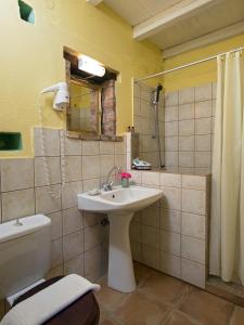 a bathroom with a sink and a toilet and a shower at Villa De Loulia in Peroulades