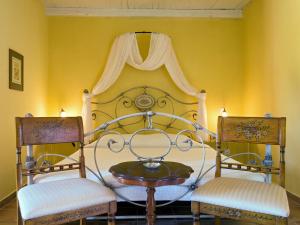 a bedroom with a bed with two chairs and a table at Villa De Loulia in Peroulades