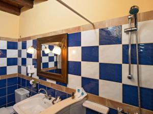 a bathroom with blue and white tiled walls and a sink at Villa De Loulia in Peroulades
