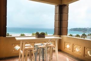 a table and chairs in a balcony with a view of the ocean at Hotel Bondi in Sydney