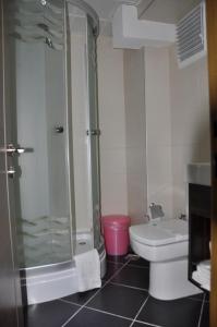 a bathroom with a shower and a toilet and a sink at Hotel Kabacam in Izmir