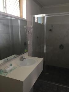 a bathroom with a sink and a mirror at Jolly Swagman Motor Inn in Goondiwindi