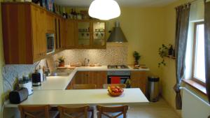 a kitchen with wooden cabinets and a bowl of fruit on the counter at Belegania Villa in Oarja