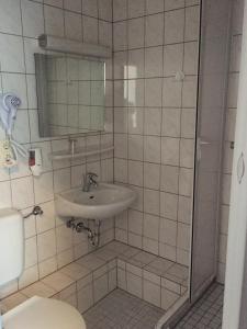 ein Bad mit einem Waschbecken und einer Dusche in der Unterkunft Hotel Stangl in Hamm