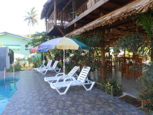 a group of chairs and umbrellas next to a pool at Shell Resort in Arugam Bay