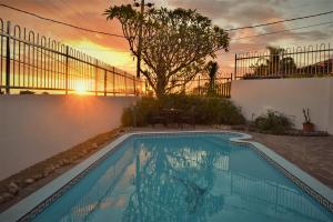 a swimming pool with a sunset in the background at Villa Roscia in Beau Vallon