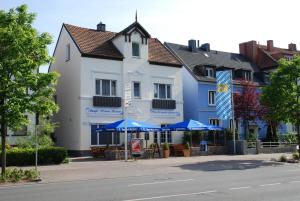 un edificio con sombrillas azules frente a una calle en Hotel Stangl, en Hamm