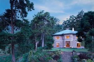 dom na wzgórzu z drzewami w tle w obiekcie Jetwing Warwick Gardens w mieście Nuwara Eliya