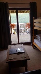 a room with a table and a view of a balcony at Letterfinlay Lodge House in Letterfinlay