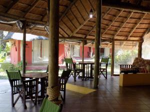 zona de comedor con mesas, sillas y sombrilla en Jump Street Chalets, en Maun