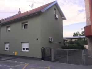 Biały dom z bramą i płotem w obiekcie Bed & Bike Zagreb studio apartment w Zagrzebiu