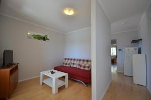 a living room with a red couch and a table at Riva1 Apartments and Rooms in Prizba