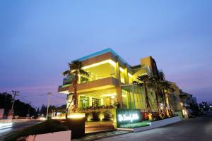 a building with palm trees in front of it at The Beverly Hills Hotel in Nakhon Ratchasima
