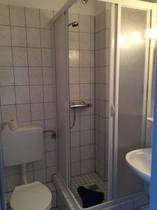 a bathroom with a shower with a toilet and a sink at Hotel Stangl in Hamm