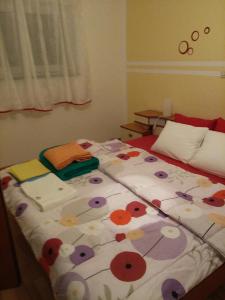 a bed with a flowered comforter in a bedroom at Apartman Gabi in Kastav