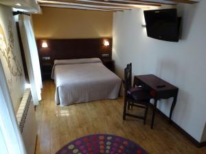 Un dormitorio con una cama, un escritorio y un televisor. en El Molino de Floren, en Santo Domingo de la Calzada