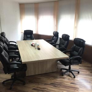 a conference room with a large wooden table and chairs at City Bridge Guest House in Bihać