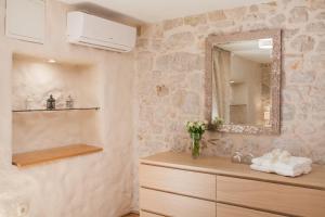 a bathroom with a mirror and a wooden dresser at Apartman Brunela-free parking in Šibenik +42 photos