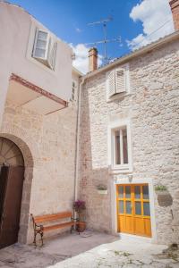 a wooden bench sitting in front of a building at Apartman Brunela-free parking in Šibenik