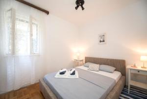 a bedroom with a bed with shoes on it at Maritimo Apartment in Split