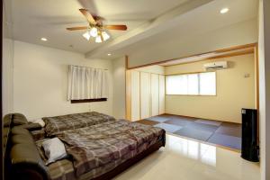 a bedroom with a bed and a ceiling fan at Terrace Resort Ginowan in Ginowan