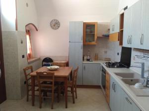 a kitchen with a wooden table and a table and chairs at La Pietra Smeraldina in Santo Spirito