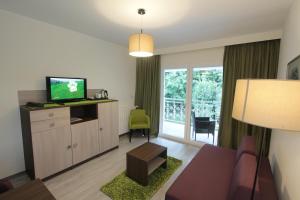 a living room with a couch and a tv at Hotel Stanger in Lovran