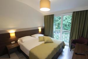 a hotel room with a bed and a window at Hotel Stanger in Lovran