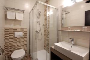 a bathroom with a toilet and a sink and a shower at Hotel Stanger in Lovran