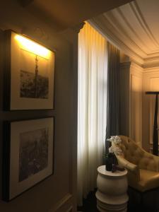 Golden Tulip New Asia Hotel The Bund Shanghai في شانغهاي: غرفة معيشة مع أريكة ونافذة