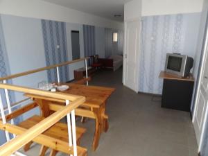 a living room with a wooden table and a television at Hotel Rebir in Daugavpils