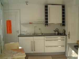 a kitchen with white cabinets and a sink at Appartement Kirschgarten Mainz Rochusstraße in Mainz