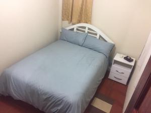 a small bedroom with a bed and a night stand at Samay Apart in Baños