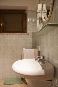 a bathroom with a white sink and a mirror at Hotel Alador in Budoni +42 photos
