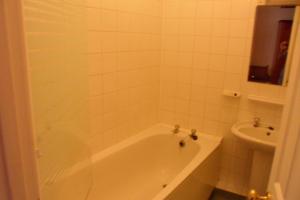 a white bathroom with a tub and a sink at Severn View Hotel in Worcester