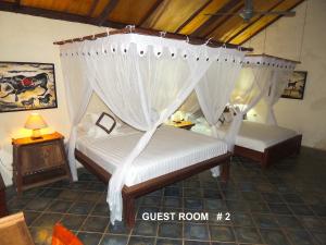 ネンブララにあるVilla Sedeoenのベッドルーム1室(天蓋付きベッド2台付)