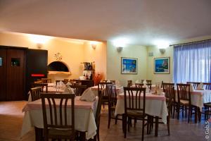 a restaurant with tables and chairs with white table cloth at Hotel Alador in Budoni