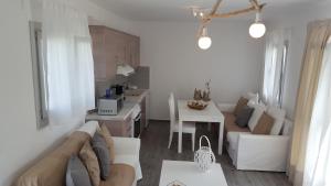 a white living room with a couch and a table at Akrotiri Villas Skyros in Skiros