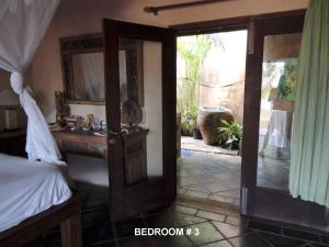 ネンブララにあるVilla Sedeoenのベッドルーム1室(ベッド1台、鏡、ドア付)