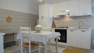 ガリポリにあるCentralissimo Perla Neraのキッチン(白いキャビネット、テーブル、椅子付)