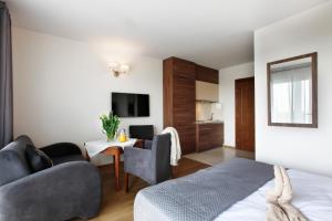 a bedroom with a bed and a living room at Jerry Apartment in Jastrzębia Góra
