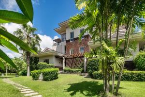 uma casa com palmeiras em frente em La Floret Villas Yalong Bay Sanya em Sanya