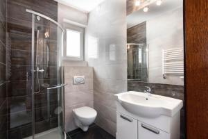 a bathroom with a toilet and a sink and a shower at Jerry Apartment in Jastrzębia Góra +53 photos